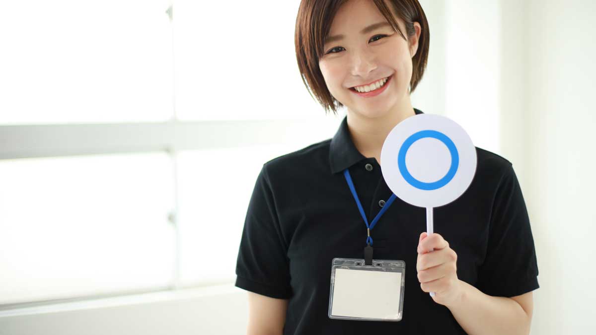 〇マークを出すトレーナーの女性